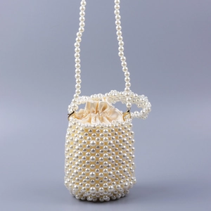 Détail du sac seau en perles fait main avec doublure en satin et fermeture à cordon