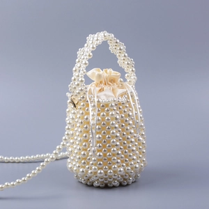 Détail du sac seau en perles fait main avec doublure en satin champagne et bandoulière