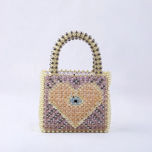 Detailed view of handmade beaded handbag with colorful heart pattern and pearl handle