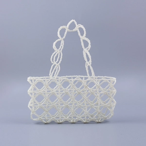 Détail du tissage de perles à la main et du motif ajouré complexe sur un sac à main élégant