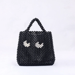 Sac à main artisanal en perles noires avec motif yeux blancs et anse structurée