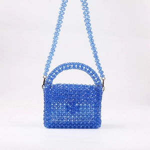 Gros plan du sac à main en perles acryliques bleu roi avec texture tissée main