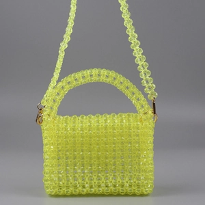 Détail macro des perles en acrylique jaune fluo et du fermoir mousqueton doré du sac