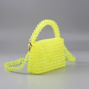 Détail du sac à main en perles acryliques jaunes avec bandoulière et fermoirs dorés