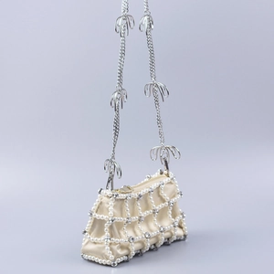 Detail of pearl lattice evening bag with crystal rhinestones and bow chain strap