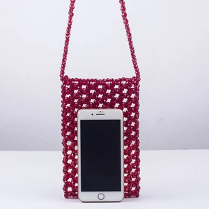 Détail du sac de téléphone en perles acryliques rouges montrant la texture et la taille