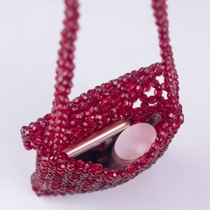 Détail d'un mini sac en perles acryliques rouges montrant sa capacité de rangement