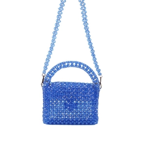 Sac à main bleu en perles acryliques avec poignée et bandoulière sur fond blanc