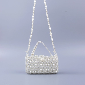 Macro shot of handcrafted hollow pearl crossbody bag showing intricate woven details
