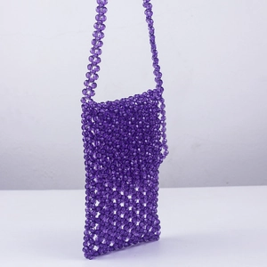 Détail du sac de téléphone en perles acryliques violettes avec texture tissée