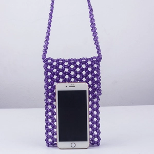Détail d'un sac de téléphone violet fait main avec des perles en résine transparentes