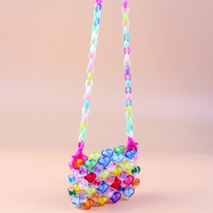 Detailed close-up of colorful heart-shaped acrylic beads on a handmade woven mini bag