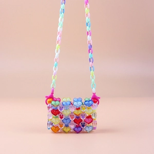 Macro shot of colorful acrylic heart beads on a handmade woven mini crossbody bag