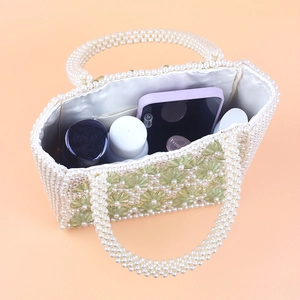Detail of beaded pearl bag with floral accents showing spacious satin lined interior