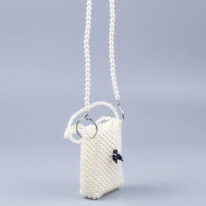 Detail view of handmade pearl crossbody bag with black beaded pattern and chain