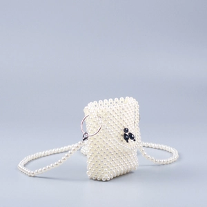 Detailed view of handmade woven pearl crossbody bag with black bead accents on pure gray background