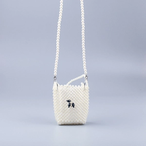 Close-up of handmade pearl mini crossbody bag with black poodle bead pattern detail
