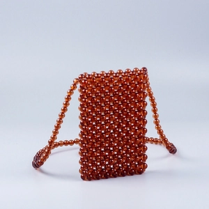 Close-up of handmade amber acrylic beaded crossbody bag with vertical woven texture