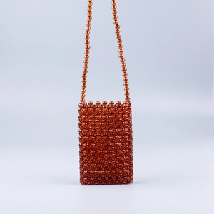 Detailed view of amber brown acrylic beaded phone bag with handmade woven texture
