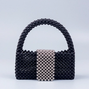 Handmade black beaded handbag with a silver rectangular accent and rounded top handle