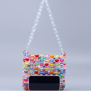 Detailed view of colorful acrylic heart beads on a handmade shoulder bag with chain