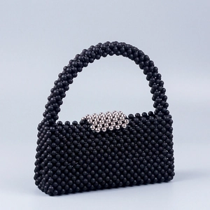 Detail of handcrafted black beaded bag featuring a honeycomb weave and silver bead clasp