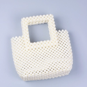 Handmade white faux pearl woven tote bag with dual top handles on a clean blue background