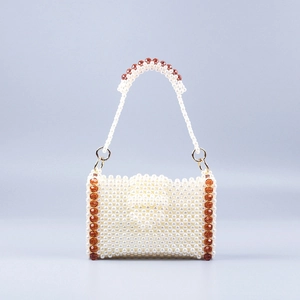 Close-up of handmade beaded handbag showing white pearls and red crystal details