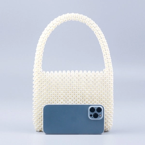 Handmade white faux pearl beaded handbag for women shown with a smartphone for scale