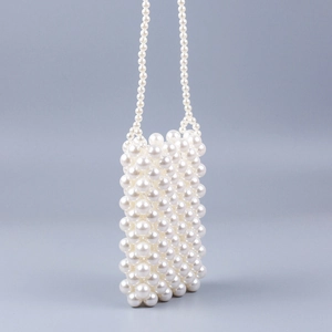 Close-up of handmade white pearl beaded mini crossbody bag with glossy texture