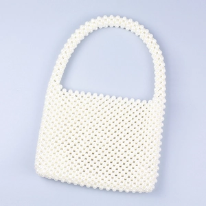 Macro shot of handcrafted faux pearl woven handbag showing intricate beaded texture