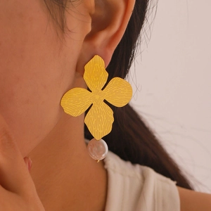 French style gold flower drop earrings with baroque pearl charms on a female model