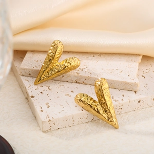 Boucles d'oreilles cœur en acier plaqué or 18K martelé sur fond de soie crème