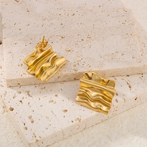 Minimalist 18K gold plated irregular square earrings with wavy texture on travertine stone