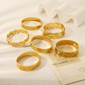 Set di sei bracciali in acciaio al titanio placcati oro con motivi a foglia e geometrici