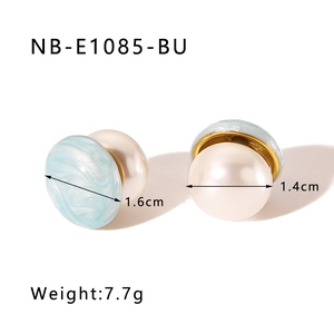Detailed view of turquoise marble disc and large pearl stud earrings with 18k gold plating