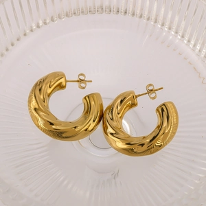 Boucles d'oreilles créoles torsadées en C plaquées or 18k pour femme sur plateau