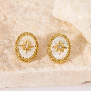 Vista macro di orecchini vintage in oro 18k con madreperla e motivo a stella