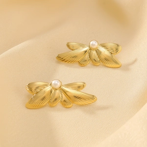 Golden feather wing stainless steel earrings with pearl on elegant silk background