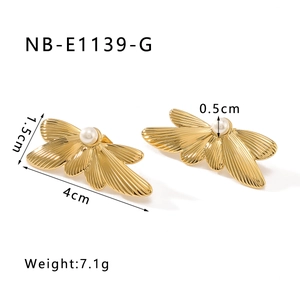 Detail showing 4cm feather wings earrings with a white pearl and 18k gold finish