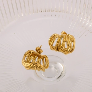 Détails macro des boucles d'oreilles créoles torsadées creuses en acier doré 18 carats
