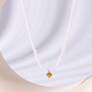 Elegante 18k vergoldete Herz-Halskette mit weißen Perlen auf einem minimalistischen Hintergrund