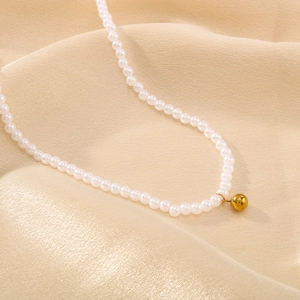 Collier de perles de style français avec pendentif doré sur fond de soie champagne