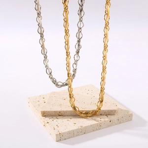Collier en maille serpent entrelacée or et argent sur pierres de travertin minimalistes