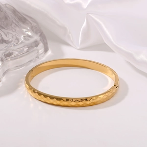 Elegante bracciale in acciaio al titanio dorato con superficie geometrica diamantata