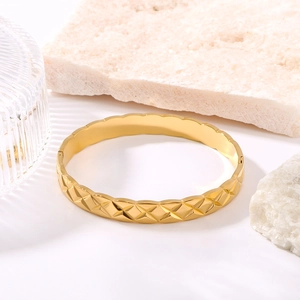 Bracciale rigido dorato in acciaio inossidabile con incisioni geometriche trapuntate lucide