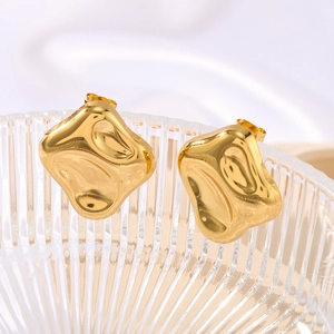 Minimalist gold irregular geometric stud earrings with liquid lava texture on glass tray