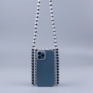 Detailed view of handmade beaded phone bag with black and white pearls and blue smartphone