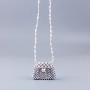 Detailed view of handmade pearl woven crossbody bag with large pearl clasp and long strap