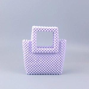 Sac à main artisanal en perles lavande avec poignée carrée et texture géométrique